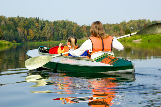 Kayaking and canoeing with family. Children and parents on kayak ride on river.