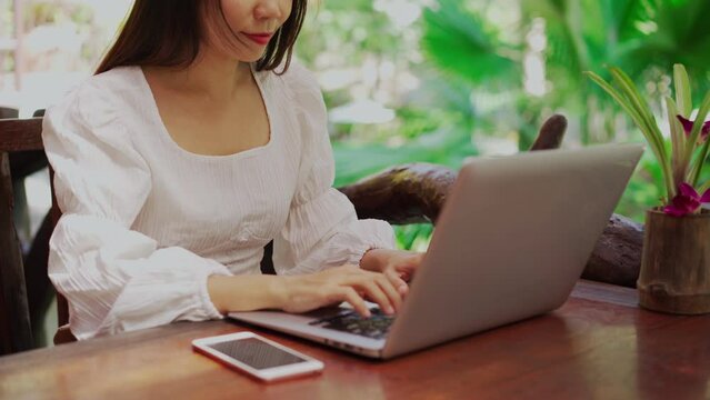 Young woman freelancer traveler working online using laptop while traveling on vacation, Freelance and workation concept	
