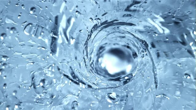 A whirlpool of water with air bubbles. Top view. Macro background.Filmed is slow motion 1000 fps.