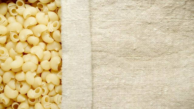 TOP VIEW: Lumache pasta under opening sackcloth