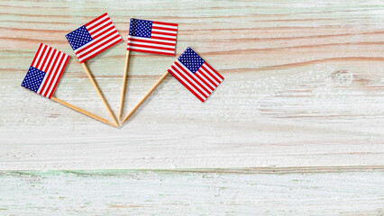 Fototapeta na wymiar Closeup studio top view shot of four small miniature paper pride American USA United States of America country national toothpick stick flags placed on old vintage wooden background with copy space