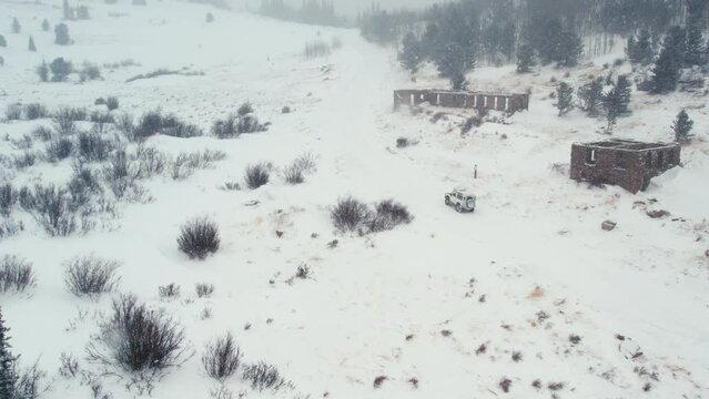 Land Rover Defender D90 SUV Parked On Snowy Backcountry Alpine Forest Road Near Rocky Mountains Nederland Boulder Colorado USA During Moderate Snowfall.