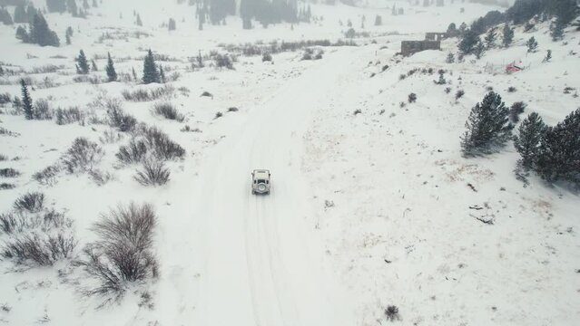 Land Rover Defender D90 SUV Off-Roading Up Snowy Backcountry Alpine Forest Road In Rocky Mountains Near Nederland Boulder Colorado USA During Moderate Snowfall.