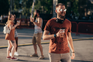 Obraz premium Group of friends drinking beer and having fun at music festival