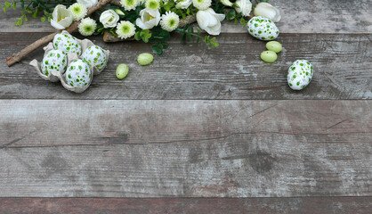 Ostereier mit Blumen auf altem Holzhintergrund.