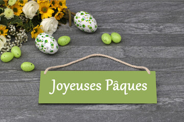 Easter decoration with Easter eggs, flowers and the text Joyeuses Pâques.