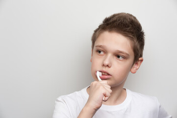 The boy cleaning his teeth using a toothbrush and toothpaste. Dental and oral care