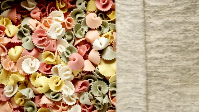 TOP VIEW: Figural multicolor pasta under opening sackcloth
