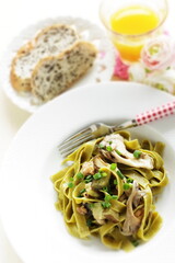Homemade Italian food, eggplant and mushroom with spinach fettuccine serving with sesame bread