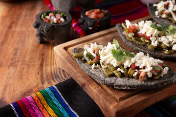 Tlacoyos with Nopales. Mexican pre hispanic dish made of blue corn flour patty filled with refried beans. Popular street food in Mexico.