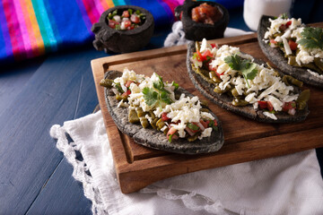 Tlacoyos with Nopales. Mexican pre hispanic dish made of blue corn flour patty filled with refried beans. Popular street food in Mexico.