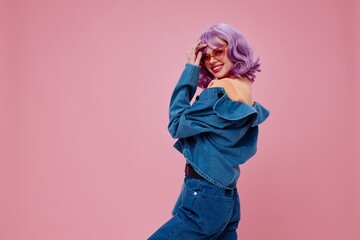 Portrait of a charming lady purple hair fashion glasses denim clothing pink background unaltered