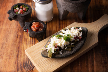 Tlacoyos with Nopales and salsa. Mexican pre hispanic dish made of blue corn flour patty filled with refried beans. Popular street food in Mexico.