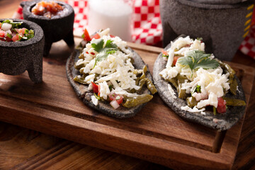Tlacoyos and Nopales. Mexican pre hispanic dish made of blue corn flour patty filled with refried beans. Popular street food in Mexico.