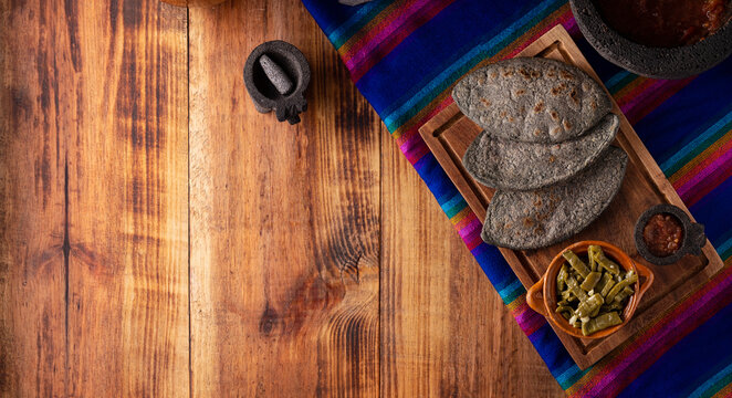 Tlacoyos. Mexican pre hispanic dish made of blue corn flour patty filled with refried beans. Popular street food in Mexico. Panoramic image with copy space