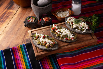 Tlacoyos with Nopales. Mexican pre hispanic dish made of blue corn flour patty filled with refried beans. Popular street food in Mexico.