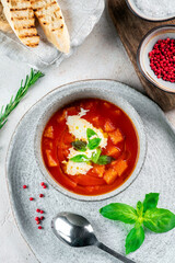 Italian vegetable soup with tomatoes, basil, cheese and vegetables in a gray bowl. Tomato cream soup top view