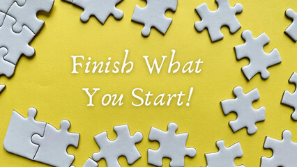 Obraz premium Finish what you start text on yellow background with white jigsaw puzzle missing pieces.