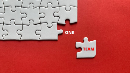 Top view of text - one team. On red background of white jigsaw missing pieces. Business concept. - obrazy, fototapety, plakaty