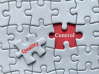 Fototapeta premium Top view of words with jigsaw puzzle background - Quality control. Business concept