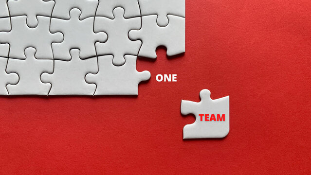 Top view of text - one team. On red background of white jigsaw missing pieces. Business concept. - Powered by Adobe
