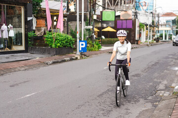 Fototapeta premium asian female cyclist in sport clothing and helmet