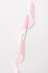 Pregnancy test isolated. Positive woman pregnant test with pink silk ribbon on white background. Medical healthcare gynecological, pregnancy fertility maternity people concept.