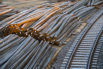 Bundles of reinforcing steel lying by the railroad tracks