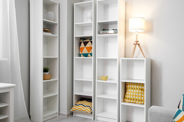 Big shelving unit with decor and glowing lamp in room