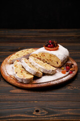 Traditional Christmas stollen cake with marzipan and dried fruit isolated on wooden background