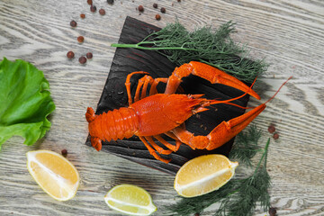 Boiled crab with lemon and spices on a wooden plate.