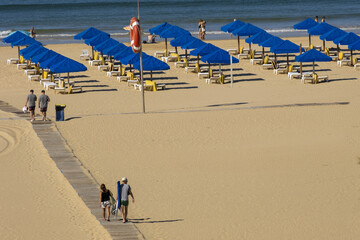 umbrella on the sand of the Beach of Praia da Rocha in Portimao, Algarve, Portugal