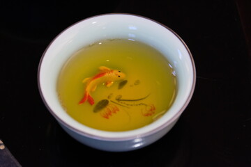 Fish in freshly brewed green tea in a white Cup