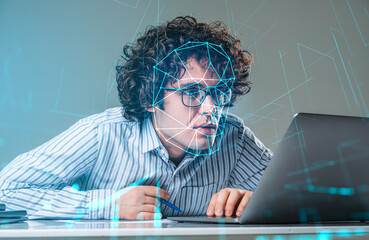 Handsome curly businessman wearing formal shirt is working on laptop