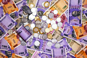 Various Indian paper currency and coin with a financial bill as a backgrounds.