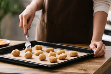 Woman preparing peanut cookies at kitchen table, closeup