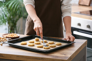 Woman preparing peanut cookies at kitchen table, closeup