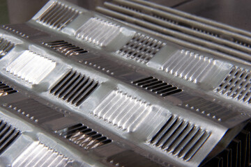 shiny metallic waves of bent metal. aluminum stamping in production