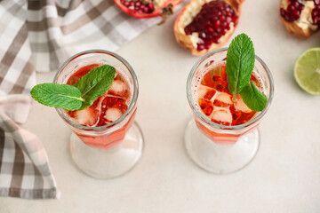 Glasses of tasty pomegranate cocktail on white background