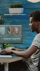 Man working as videographer editing video with musical footage for freelance project. Film maker doing retouch work with visual effects on computer for montage production. Content creator