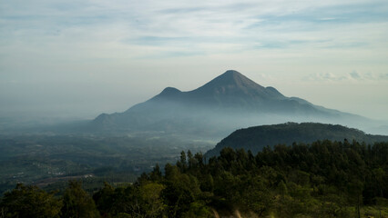 Landscape view of misty Mount Penanggungan at early morning, East java, Indonesia, landscape wallpaper, defocused background 