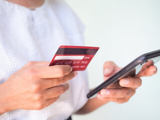 Close up woman holding credit card and mobile smartphone on white background.for shopping online buy and pay.technology internet commmunication e-commerce for busindess finance and lifestyles concept.