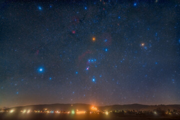 Landscape and night sky with the Orion Constellation photographed from Wachenheim in Germany.