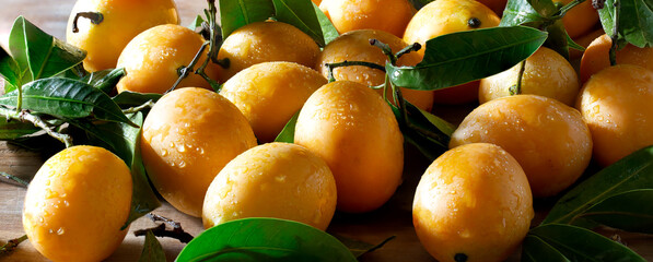 Pile of plango fruit (Thai call Mayong chid) Thai fruit in wooden bowl and on wooden plank