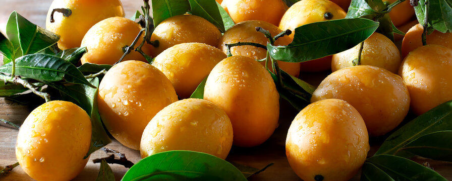 Pile of plango fruit (Thai call Mayong chid) Thai fruit in wooden bowl and on wooden plank
