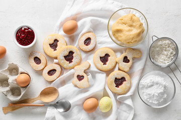 Tasty Easter cookies and ingredients on light background