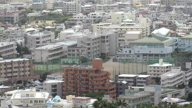 NAHA, OKINAWA, JAPAN - AUGUST 2021 : Aerial view of school in Naha city. Primary school or junior high school. Playground and building.