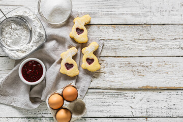 Fototapeta na wymiar Tasty Easter cookies and ingredients on white wooden background