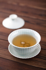 Open the lid of the cup of tea