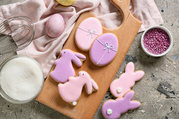 Fototapeta na wymiar Wooden board with tasty Easter cookies and painted egg on grey background